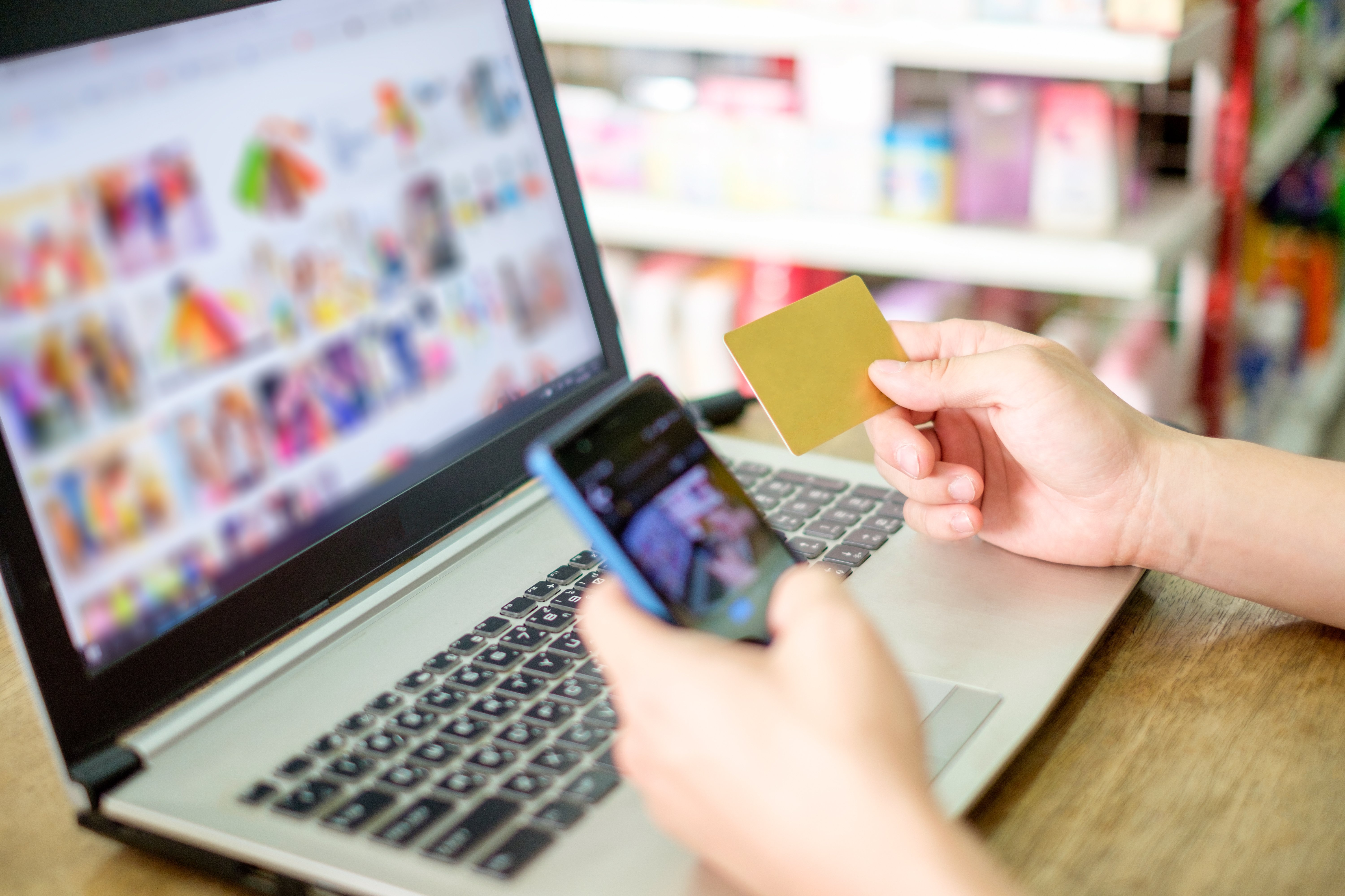 hand-holding-credit-card-and-using-laptop-with-sma-2023-11-27-05-26-06-utc